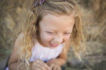 Close-up of elementary age girl laughing in barn. — Stock Photo