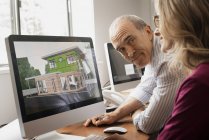 Architects discussing green construction project on computer monitor in office. — Stock Photo