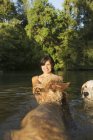 Mid adult woman swimming with two dogs in lake water. — Stock Photo