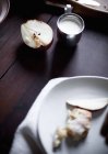 Frutta a pera affettata e servita su piatto di porcellana bianca con brocca di crema . — Foto stock