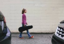 Ragazza pre-adolescente che cammina con caso violino sulla strada urbana . — Foto stock