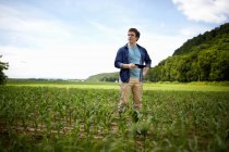 Молодий фермер використовує цифровий планшет в органічному полі кукурудзи . — стокове фото