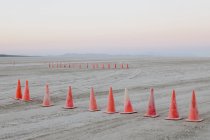Fila de conos de tráfico en la superficie plana del desierto de Black Rock, Nevada . - foto de stock