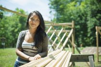 Woman leaning on wooden logs at traditional farm in countryside. — Stock Photo