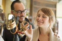 Couple looking at antique jewelry on mannequin hand. — Stock Photo