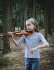 Vorpubertäre Geigerin spielt Geige im Wald. — Stockfoto