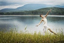 Woman dancing in open air along lake shore near Woodstock, New York State, USA — Stock Photo