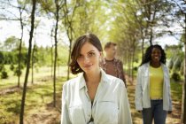 Young women and man walking on country path in summer. — Stock Photo