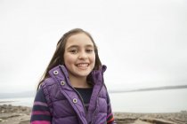 Chica pre-adolescente en color púrpura dorada en la orilla del lago . - foto de stock