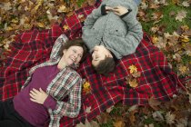 Vista aerea di donna e bambino sdraiato sulla coperta da picnic tartan . — Foto stock