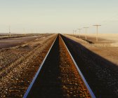 Залізничні колії, що простягаються плоских Юта пустельний ландшафт в сутінках, США. — стокове фото