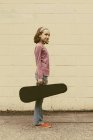 Pre-adolescent girl carrying violin case on urban street. — Stock Photo