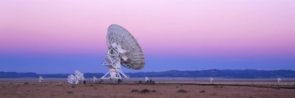 Large array radio telescope in valley under pink sky at sunset, New Mexico, USA — Stock Photo