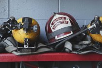 Fireman helmets and gear on shelf, close-up — Stock Photo
