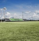 Bleachers at high school grassy sports field — Stock Photo