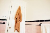 Bathrobe hanging on bathroom door — Stock Photo