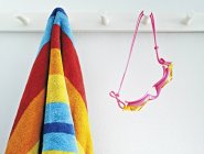 Close-up of beach towel and goggles hanging indoors — Stock Photo