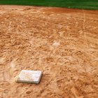 Base no campo de basebol com pegadas, close-up — Fotografia de Stock
