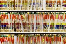 Colorful medical folders stacked on shelves — Stock Photo