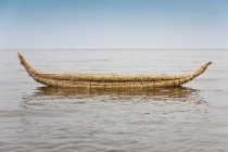 Kayak hecho de cañas flotando en el agua - foto de stock
