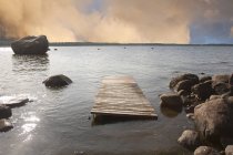 Molo di legno galleggiante sulla riva rocciosa in Estonia — Foto stock