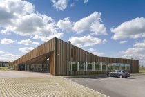 Edificio per uffici contemporaneo e auto sotto il cielo blu con nuvole, Estonia — Foto stock