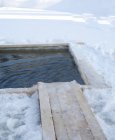 Furo de gelo de pesca no campo de neve — Fotografia de Stock