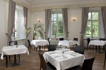 Placez les paramètres sur les tables dans un restaurant de luxe, Vihula Manor, Estonie — Photo de stock