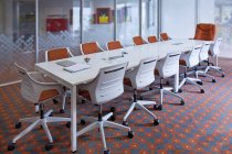 Sala de conferências vazia com mesa longa e cadeiras — Fotografia de Stock