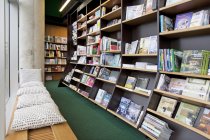 Livraria banco de leitura e prateleiras com livros — Fotografia de Stock