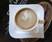 Copa de café con leche con diseño de hoja, vista superior - foto de stock