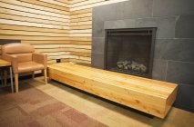 Sofisticada sala de espera con chimenea y banco de madera en Vancouver, Canadá - foto de stock