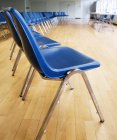 Linhas de cadeiras azuis em auditório vazio interior — Fotografia de Stock