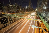 Bridge leading to New York City illuminated downtown, USA — Stock Photo