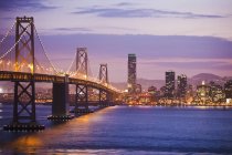 Puente que conduce a la ciudad de San Francisco iluminado por la noche, California, EE.UU. - foto de stock