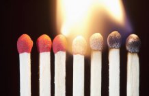 Close-up of burning matches against dark background — Stock Photo