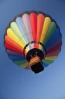 Balão de ar quente em voo contra o céu azul — Fotografia de Stock