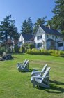 Газон Hastings House со стульями и гостиничными зданиями в Salt Spring Island, Британская Колумбия, Канада — стоковое фото