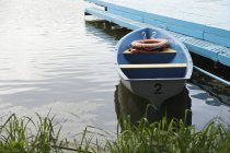 Small moored boat at painted pier by lakeside, Moscow, Russia — Stock Photo
