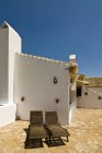 Sillas en cubierta por edificio blanco, Andalucía, España - foto de stock