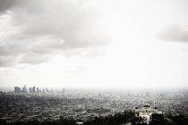Los Angeles skyline and Griffith Observatory beneath cloudy sky, USA — Stock Photo