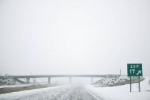 Verschneite Autobahn mit Verkehrszeichen, idaho, USA — Stockfoto