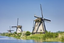 Moinhos de vento na margem do rio, Kinderdijk, Países Baixos, Europa — Fotografia de Stock