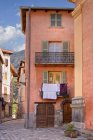 Urban French streetscape with old traditional houses and laundry hanging on balconies, Saint Etienne de Tinee, France — Stock Photo