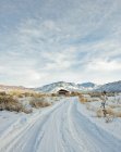 Snowy trail leading to remote house — Stock Photo