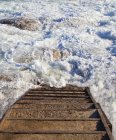 Stairway and rocky steps to ocean water surf — Stock Photo