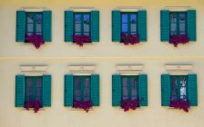 Colorful wooden shutters and flowers of building, Karlovy Vary, Czech Republic — Stock Photo