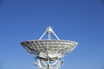 Antena de radiotelescopio contra cielo azul - foto de stock