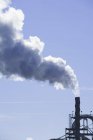 Cheminée industrielle avec nuages de fumée de centrale électrique contre ciel bleu — Photo de stock