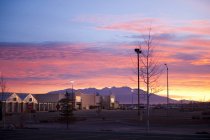 Salida del sol sobre el centro comercial con cielo rojo y montañas en la distancia, Alamosa, Colorado, EE.UU. - foto de stock